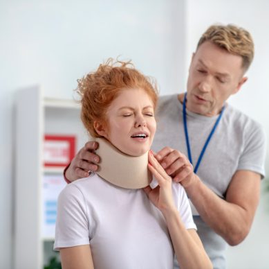 Man treating woman with neck brace